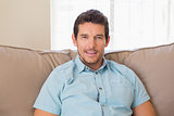 Portrait of content relaxed man sitting on couch