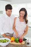 Young couple cutting vegetables in kitchen