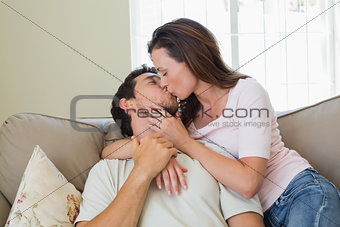 Loving relaxed couple kissing in living room