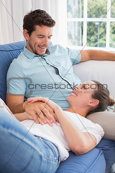 Happy woman resting on mans lap on couch