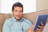 Smiling man using digital tablet at home