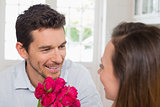 Happy man and woman with flowers at home