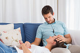 Relaxed woman resting on mans lap on couch