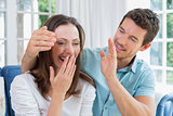 Close-up of a man surprising woman in living room