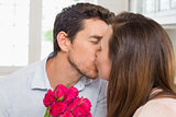 Close-up of a loving couple kissing with flowers