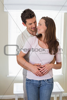 Loving man embracing woman from behind