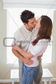 Loving young couple kissing at home