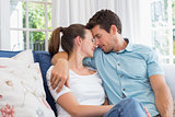 Loving young couple sitting on couch