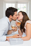 Loving young couple kissing with wine glasses