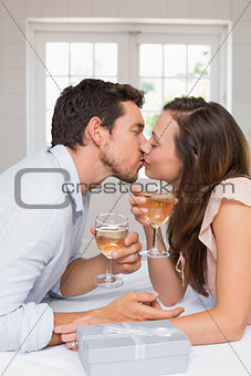 Loving young couple kissing with wine glasses
