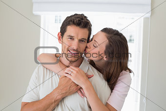 Woman embracing and kissing man from behind