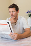 Man reading newspaper at home
