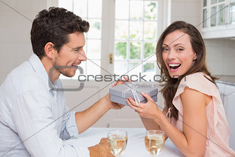 Young man giving a happy woman gift box