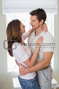 Loving man embracing woman at home