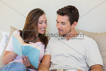 Loving relaxed couple reading book on couch