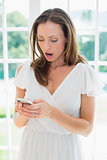 Shocked woman reading text message