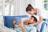 Loving couple with digital tablet in living room