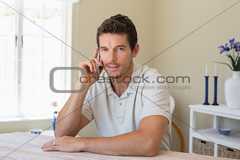 Relaxed man using mobile phone at home