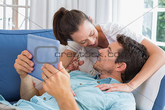 Loving couple with digital tablet in living room
