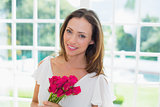 Beautiful young woman with flowers at home