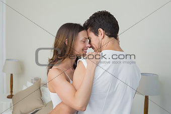 Loving young couple embracing at home