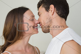 Loving young couple about to kiss at home