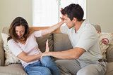Man consoling a sad woman in living room