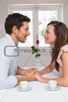 Loving young couple holding hands at home