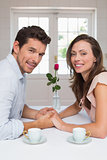 Loving young couple holding hands at home