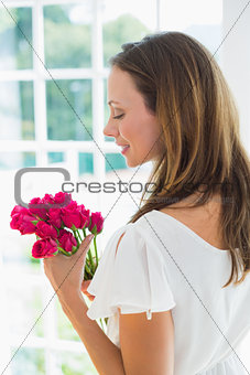 Thoughtful beautiful young woman with flowers