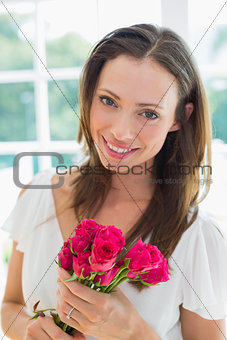 Beautiful young woman with flowers at home