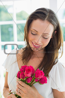Thoughtful woman with flowers at home