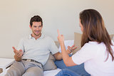 Cheerful couple having a conversation in bedroom