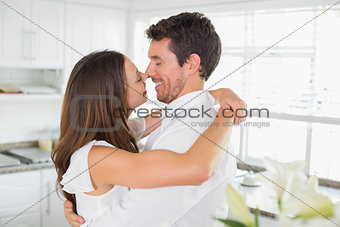 Loving young couple embracing in kitchen