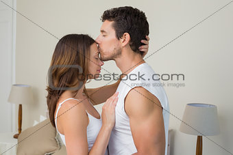Loving young man kissing woman on forehead