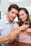 Happy loving couple with wine glasses at home