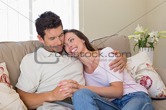 Loving couple sitting on couch at home