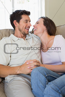 Cheerful relaxed couple sitting on couch