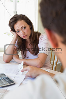 Upset woman and man sitting with home bills
