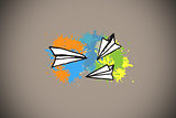 Composite image of paper airplanes on paint splashes