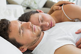 Relaxed couple sleeping together in bed