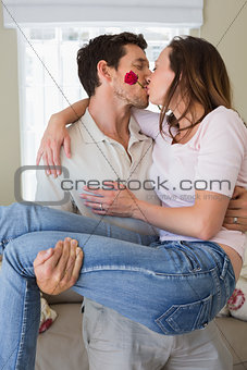 Man carrying woman as he kisses her