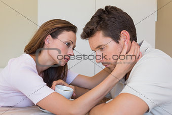 woman consoling a sad man at home