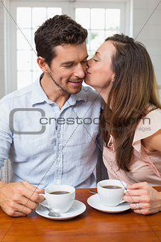 Loving couple with coffee cups at home