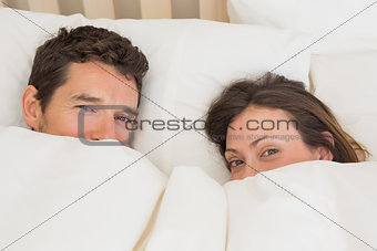 Relaxed couple lying together in bed