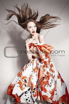 young beautiful asian brunette in gorgeous dress, motion shot