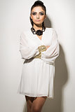 Vogue. Beautiful woman posing in white dress