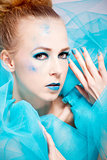 beautiful woman with extreme colorfull make up in turquoise