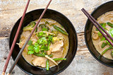 Bowls of Thai green curry with chopsticks