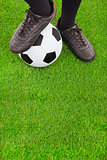 Soccer player's feet  and football on field 